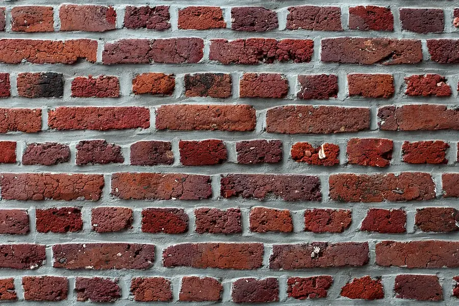 Red brick masonry wall with running bond coursing and mortar joints