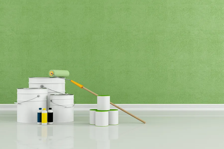 Freshly painted interior wall beside paint cans and a roller
