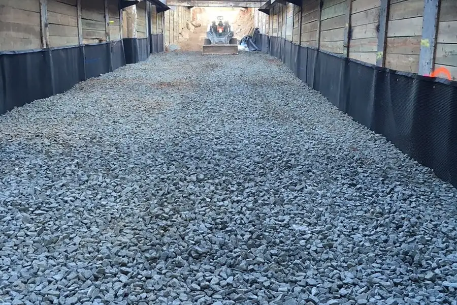Crushed stone subbase spread along a shored foundation trench